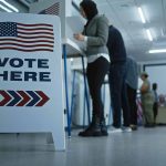 People voting in a booth.