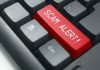 Close-up of keyboard with red "SCAM ALERT" key.