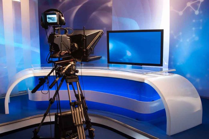 TV studio with camera and empty anchor desk.