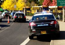 Police cars and school buses on a road.