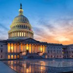 U.S. Capitol building illuminated at sunset.