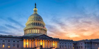 U.S. Capitol building illuminated at sunset.