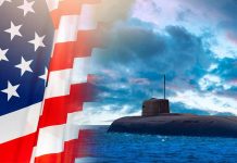 American flag and submarine at sea under a cloudy sky.