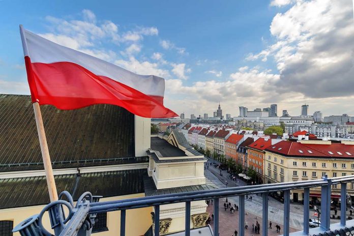 Polish flag over cityscape with buildings and cloudy sky.