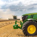 A green tractor in a wheat field.