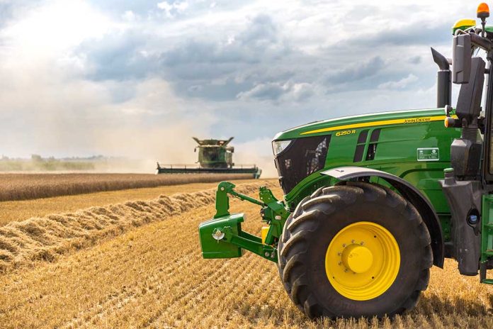 A green tractor in a wheat field.