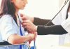 Doctor checking patient's heartbeat with stethoscope.