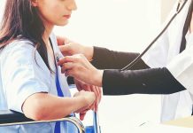 Doctor checking patient's heartbeat with stethoscope.