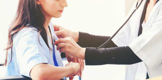 Doctor checking patient's heartbeat with stethoscope.