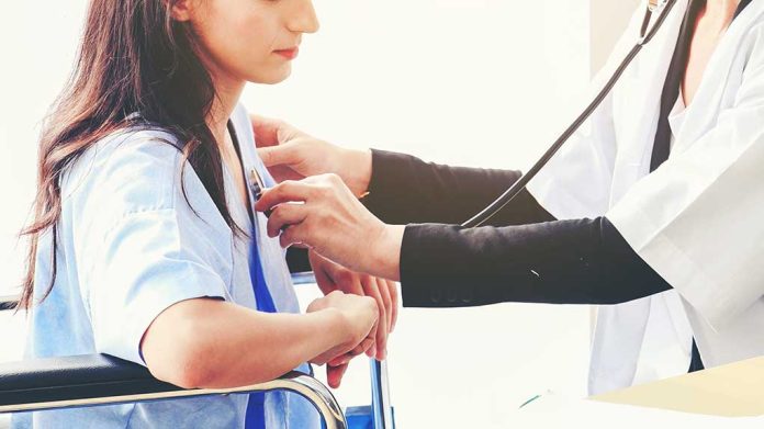 Doctor checking patient's heartbeat with stethoscope.