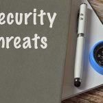 Security threats text beside pen and compass on notebook.