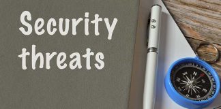 Security threats text beside pen and compass on notebook.