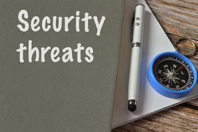 Security threats text beside pen and compass on notebook.