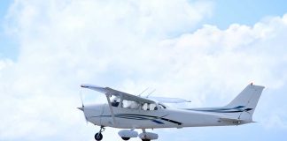 Small plane flying in a cloudy sky.