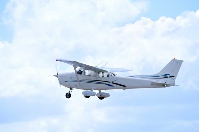 Small plane flying in a cloudy sky.