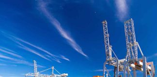 Cargo ship docked at port with cranes unloading.