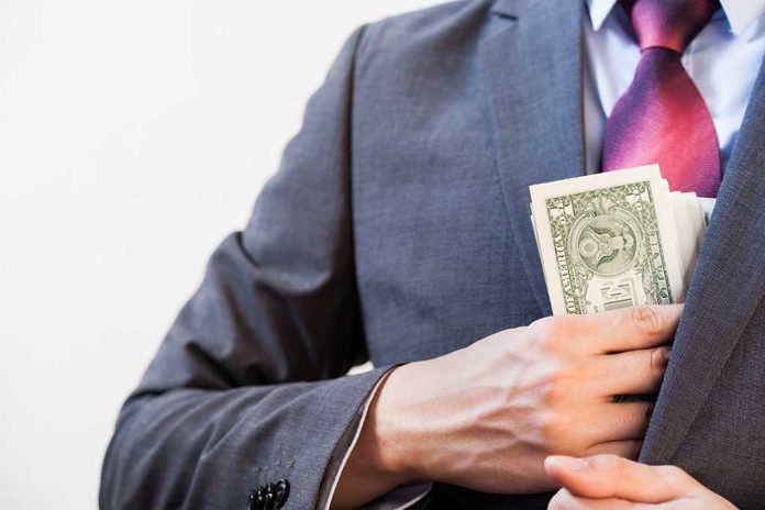 Person in suit putting money in jacket pocket.