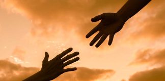 one hand reaching toward another for help