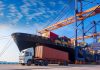 Cargo ship and truck at a busy port.