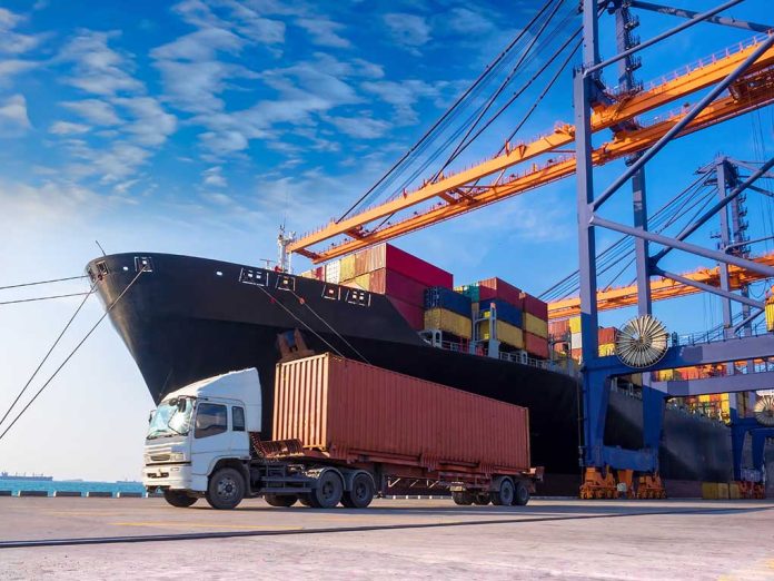 Cargo ship and truck at a busy port.