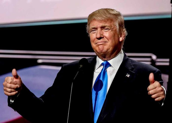 Man in suit giving thumbs-up gesture on stage.