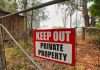 Red Keep Out Private Property sign on gate