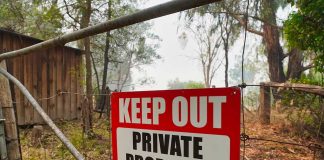 Red Keep Out Private Property sign on gate