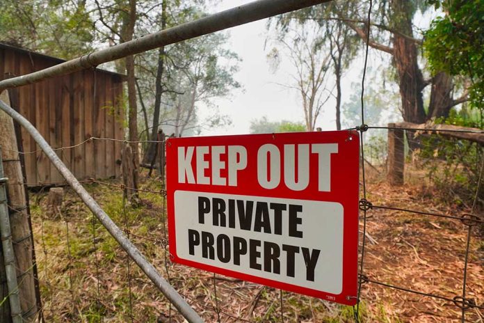 Red Keep Out Private Property sign on gate