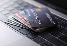 Stack of credit cards on a laptop keyboard.