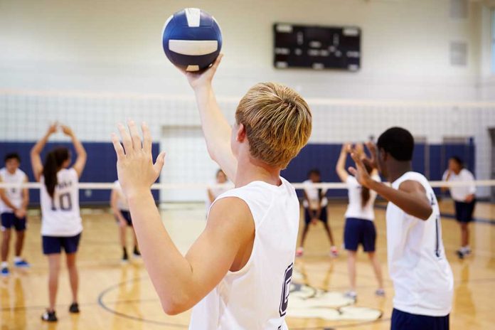 Players about to serve a volleyball in gym.