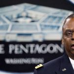 Man speaking in front of Pentagon sign.