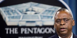 Man speaking in front of Pentagon sign.