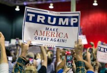 Crowd holding a "Trump Make America Great Again" sign.