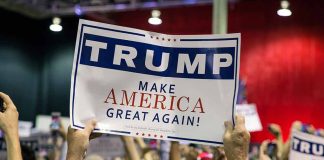 Crowd holding a "Trump Make America Great Again" sign.