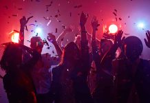 Partygoers dancing with confetti and colorful lights.