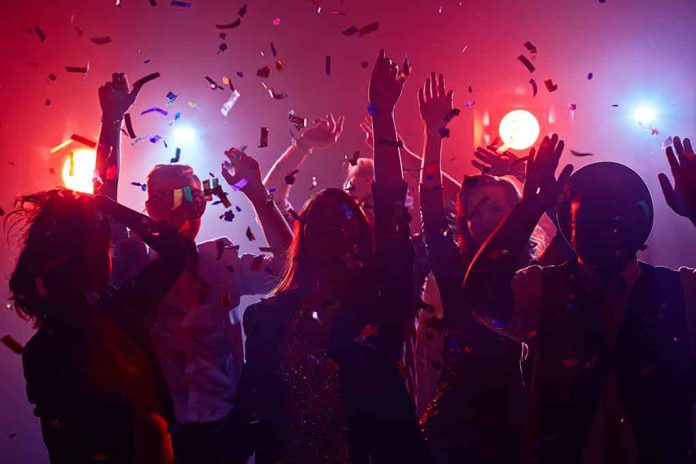 Partygoers dancing with confetti and colorful lights.