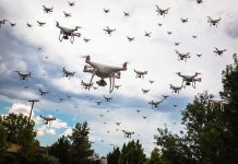 Many drones flying in a cloudy sky.