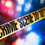 Yellow crime scene tape with blurred lights background