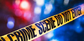 Yellow crime scene tape with blurred lights background