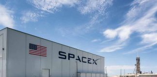 SpaceX building with American flag and launch pad.