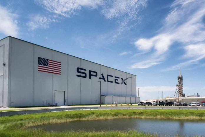 SpaceX building with American flag and launch pad.