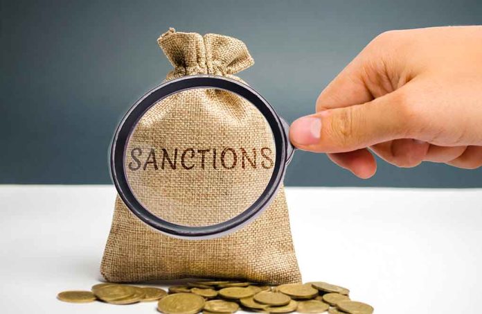 Hand holding magnifying glass over sack labeled "Sanctions".