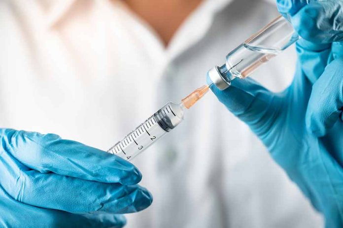 Gloved hands preparing syringe with vaccine vial.