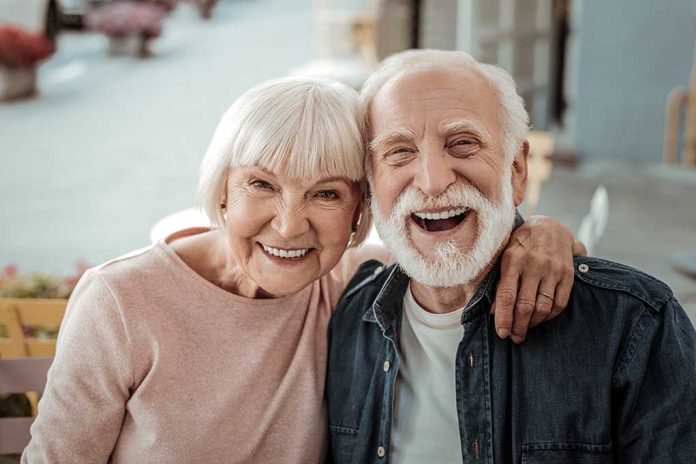 Elderly couple smiling together outdoors.