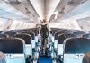 Person walking down empty airplane aisle