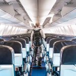 Person walking down empty airplane aisle