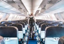 Person walking down empty airplane aisle