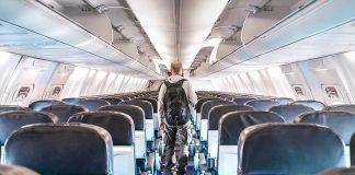 Person walking down empty airplane aisle