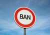 Traffic sign with the word BAN against sky