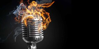 Vintage microphone engulfed in flames and smoke.